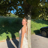 Robe midi Marguerite en satin à pois noirs et blancs, dos nu et bretelles.