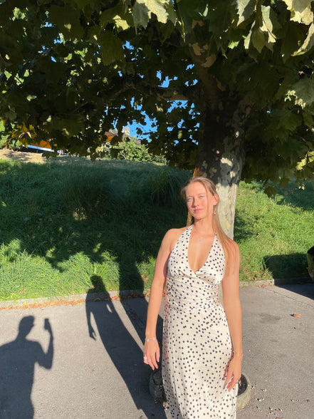 Robe midi Marguerite en satin à pois noirs et blancs, dos nu et bretelles.